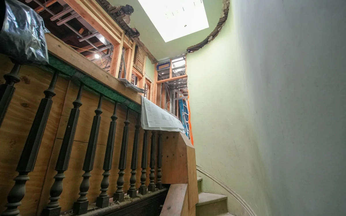 Original wood staircase inside a historic house during a careful interior renovation