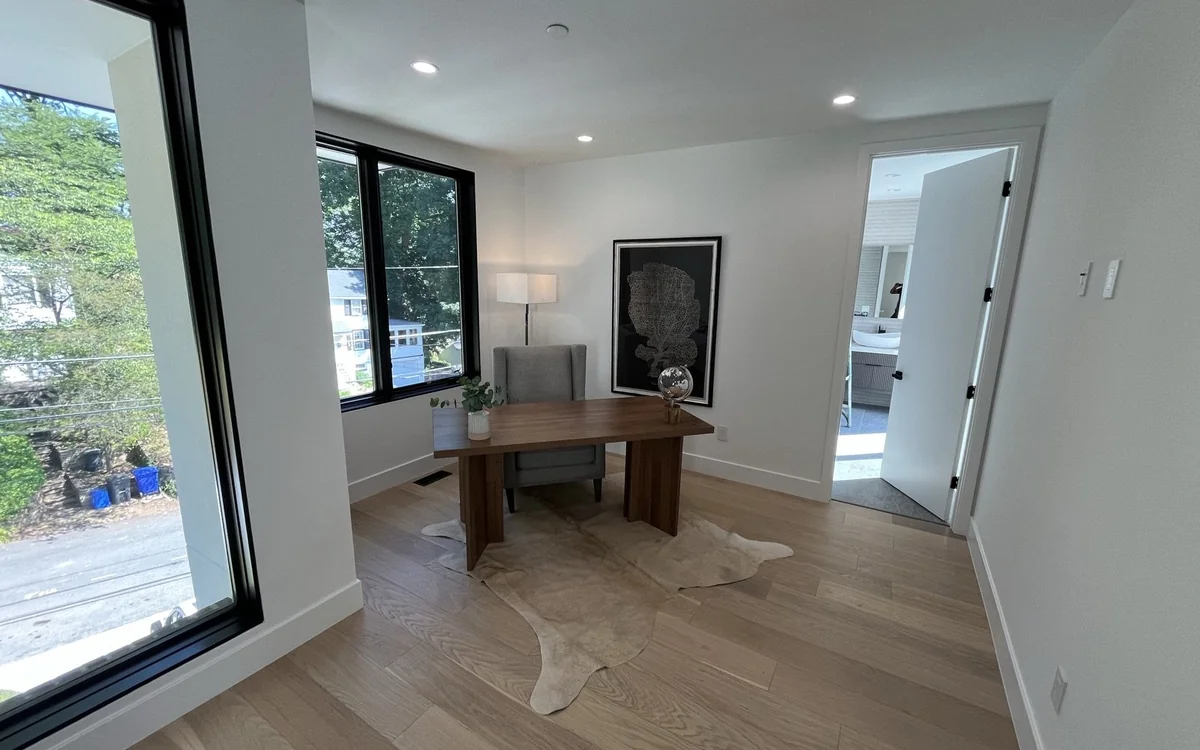 Dedicated home office with a desk, natural light, and wide-plank flooring