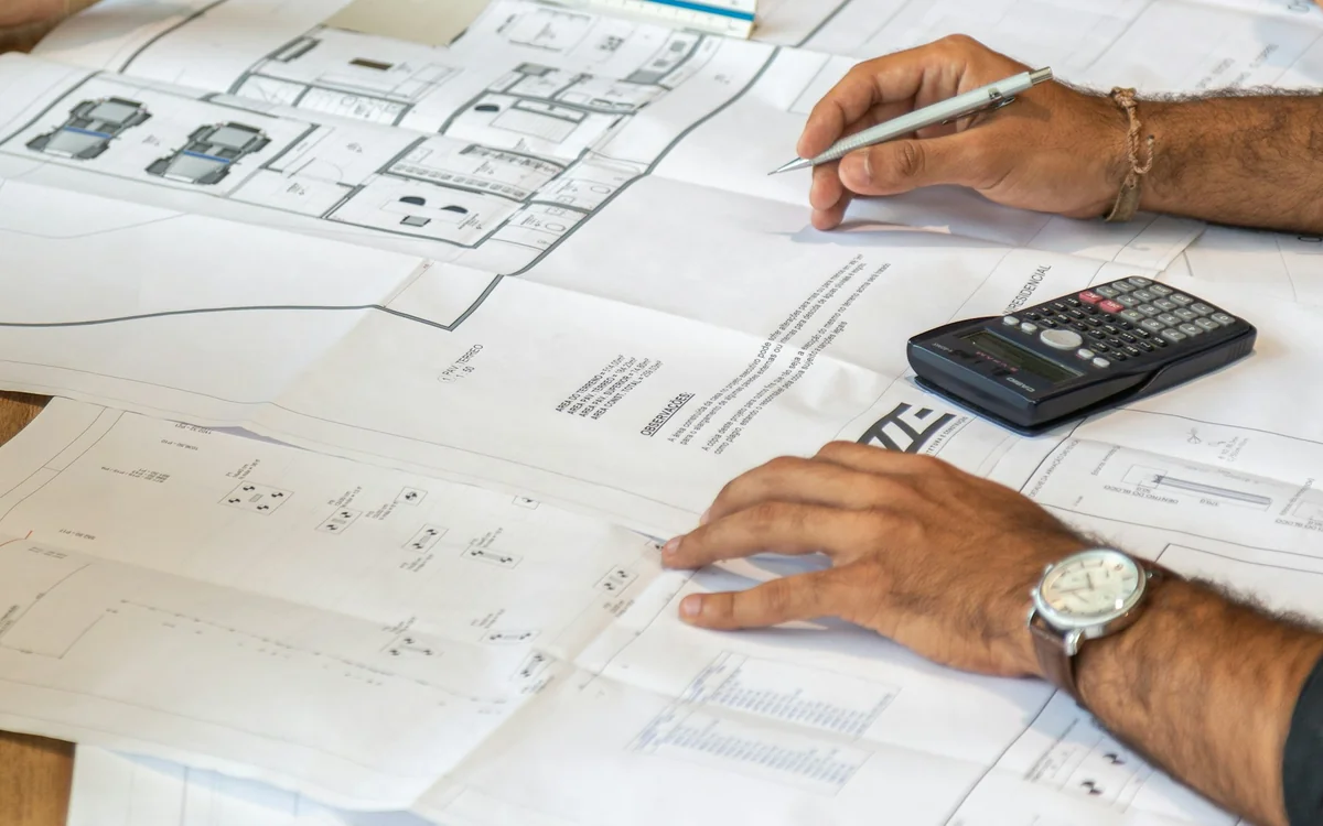 Home renovation team reviewing architectural plans together before construction