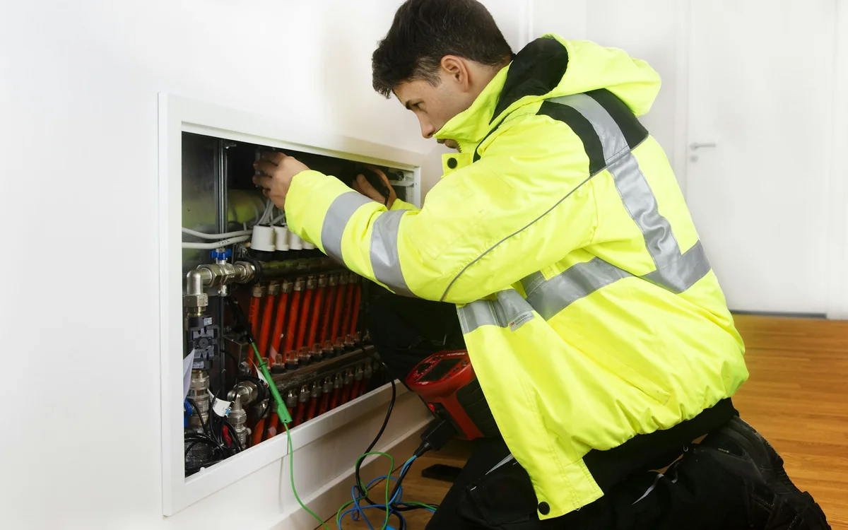 HVAC technician servicing a residential mechanical system with professional diagnostic equipment