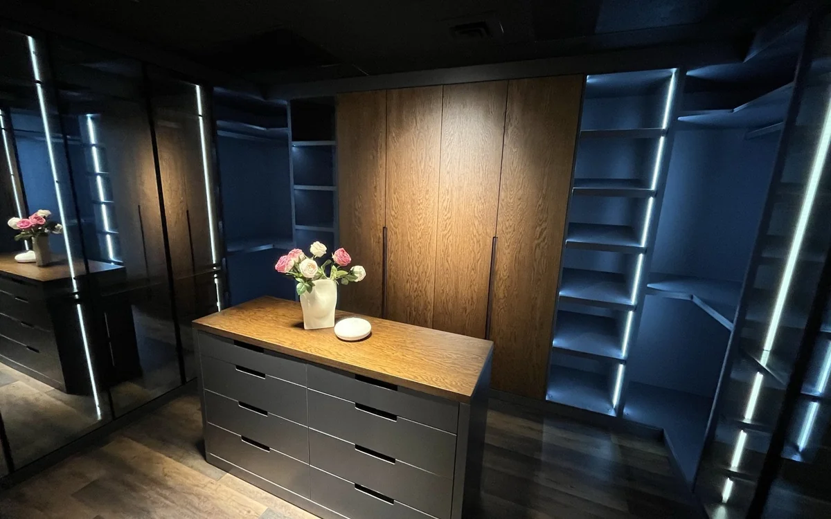 Custom floor-to-ceiling wood millwork with integrated lighting and closet storage