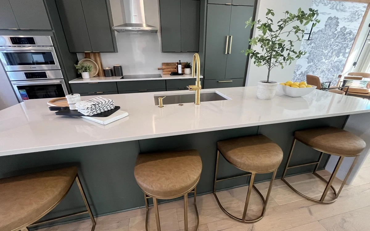 Large quartz kitchen island with bar seating, storage, and open circulation space